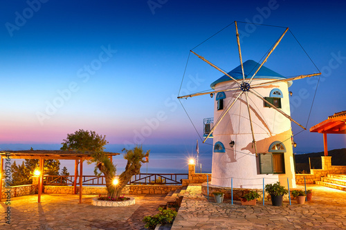 Traditional Wind Mills in Greece  Zakynthos Island. Incredibly romantic sunrise on Zakinthos. Amazing sunset view on old mill with multicolored clouds. Old Windmill in Agios Nikolaos near blue caves.