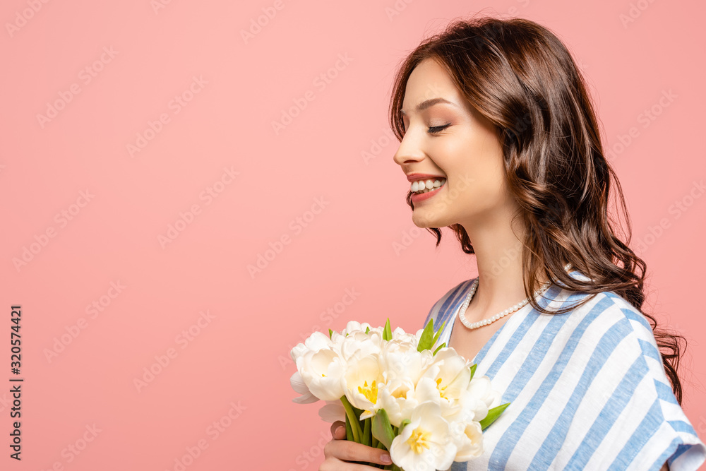happy girl smiling with closed eyes while holding bouquet of white tulips isolated on pink happy girl smiling with closed eyes while holding bouquet of white tulips isolated on pink