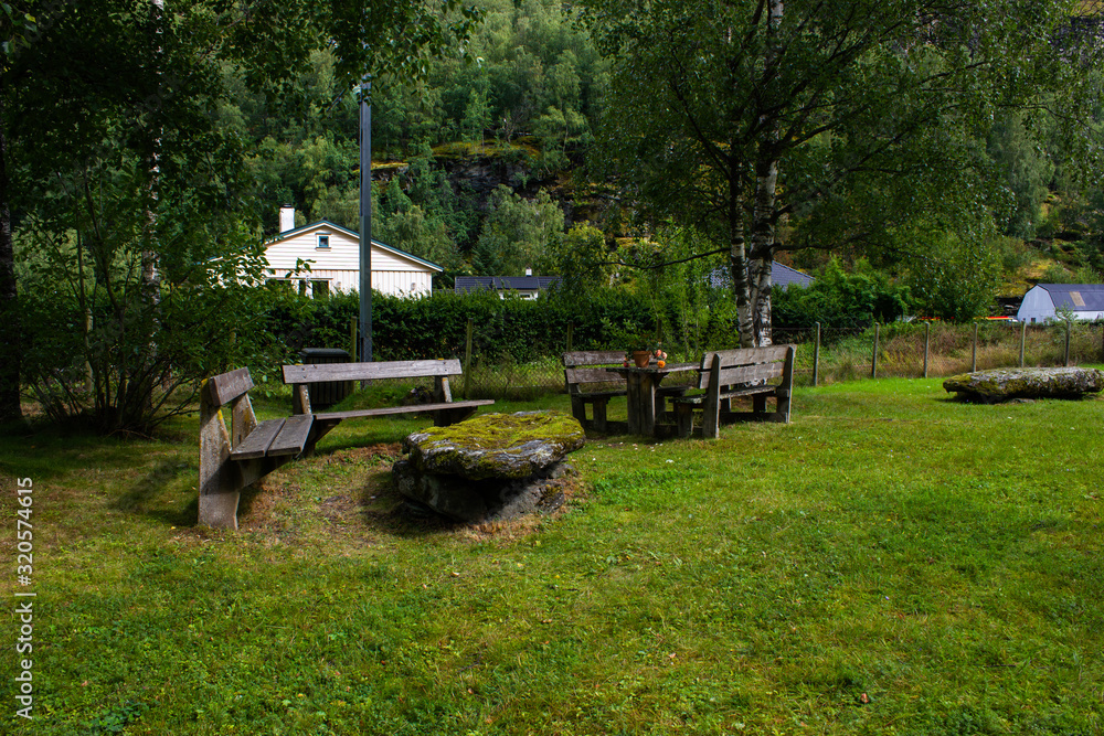 Cozy park with wooden benches and a stone table in Norway