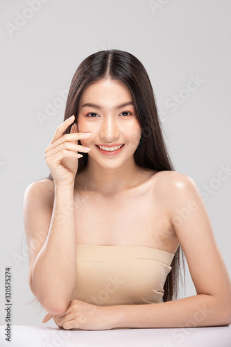 Beautiful Asian young woman touching soft cheek smile with clean and fresh skin Happiness and cheerful with positive emotional,isolated on white background,Beauty and Cosmetics Concept