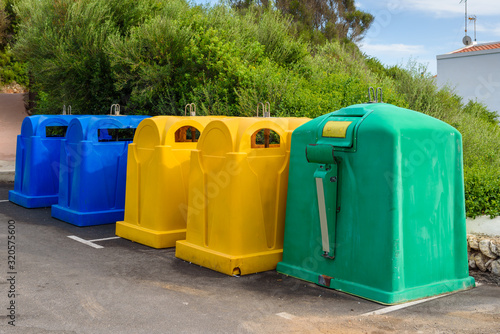 A row of colorful dustbins for waste segregation.