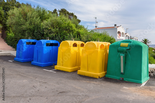 A row of colorful dustbins for waste segregation.