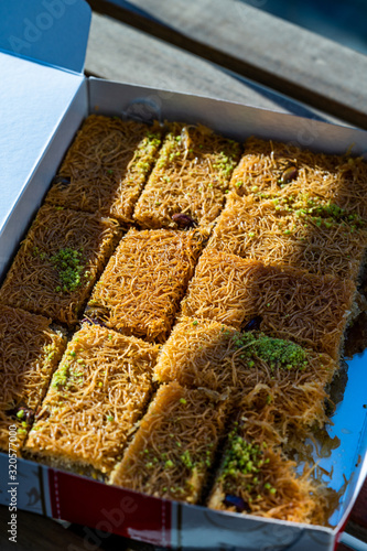 Take Away Turkish Dessert Kadayif with Pistachio Powder in Plastic Box / Package. photo