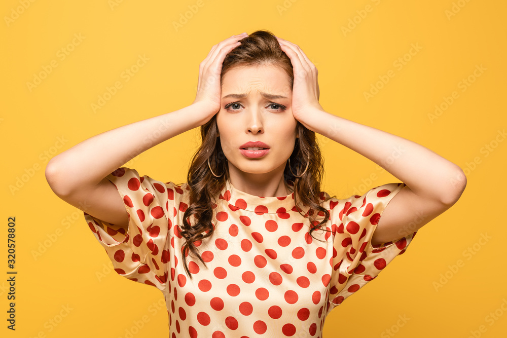 exhausted young woman touching head while suffering from headache isolated on yellow exhausted young woman touching head while suffering from headache isolated on yellow