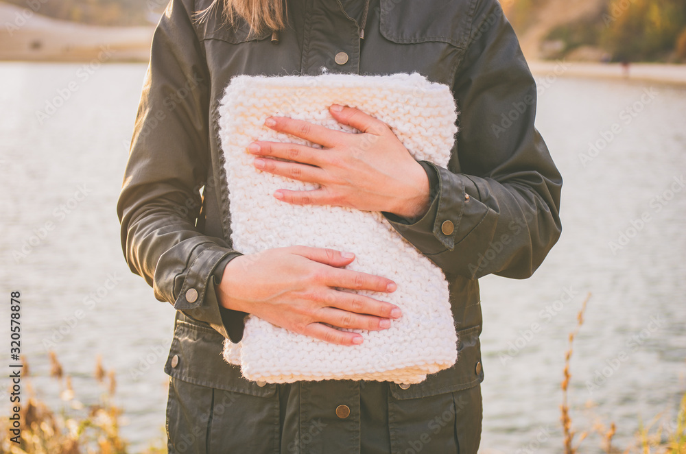 Woman demonstrates white knitted snood outdoors