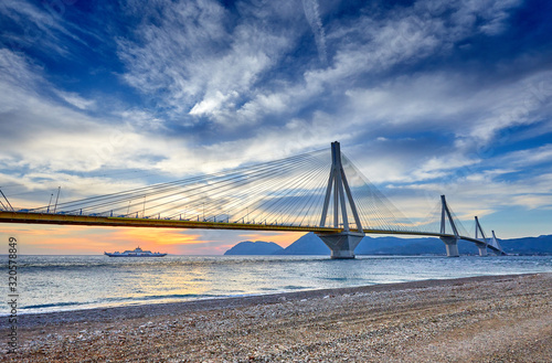 Sunset view on the bridge near Patras. Suspension bridge crossing Corinth Gulf strait  Greece  Europe. Second longest cable-stayed bridge in the world. Dramatic red sky under a Rion-Antirion Bridge.