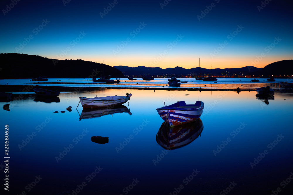 Amazing sunset (sunrise) in Greece. Boats in the bay on the coast. Relax on the beach. Sunrise bay with boats. Beautiful landscape.