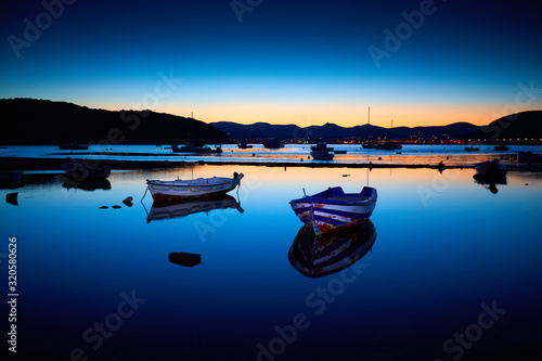 Amazing sunset (sunrise) in Greece. Boats in the bay on the coast. Relax on the beach. Sunrise bay with boats. Beautiful landscape.