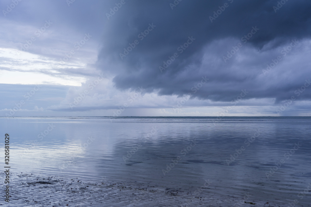 Cloudy sky during sunrise and sea water on the island of Zanzibar, Tanzania, Africa