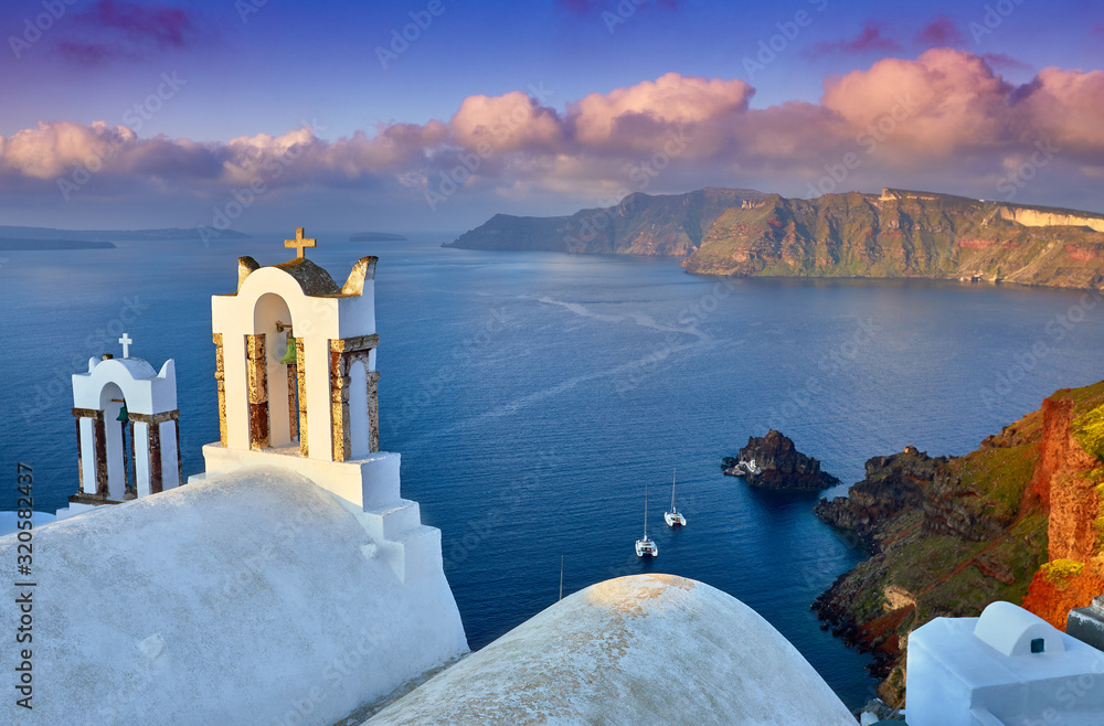 Fototapeta premium Fira town on Santorini island, Greece. Incredibly romantic sunrise on Santorini. Oia village in the morning light. Amazing sunset view with white houses. Island of lovers