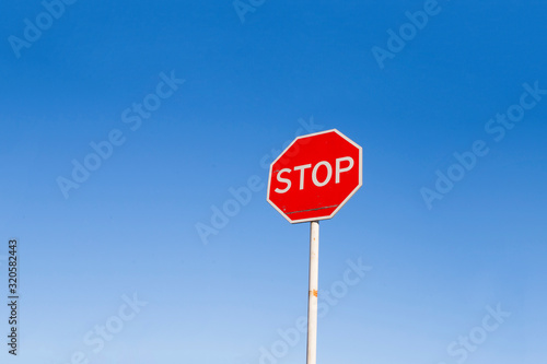 Stop sign against a blue sky. Danger warning. Road sign.