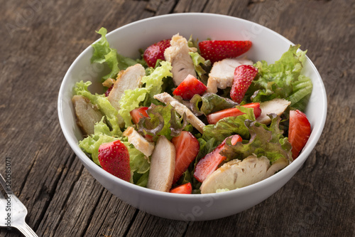 Caesar salad. Caesar salad with fresh lettuce, parmesan, fried croutons, chicken and strawberries. Restaurant food, close up. Meat salad. Close up view.