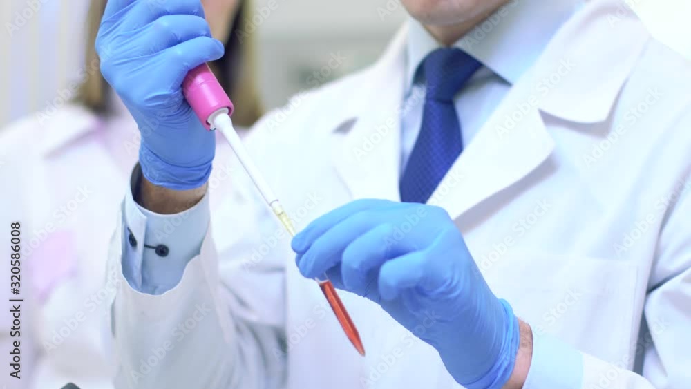 A group of scientists conducts research in a scientific laboratory using advanced technology. Liquid intake close-up. A group of scientists conducts research in a scientific laboratory using advanced technology. Liquid intake close-up.