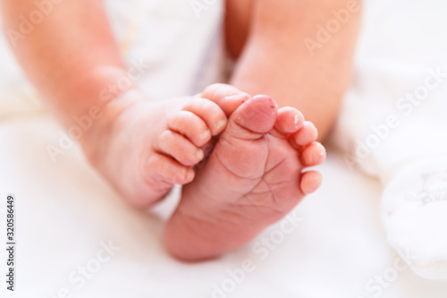 Newborn's legs are small in the hands of parents © Александр Бутылов