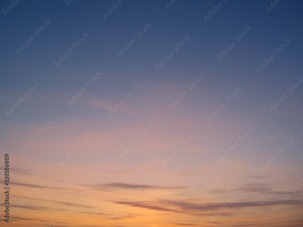 Clear sky with small clouds on the horizon at sunset. Beautiful colorful sky at sunset background.