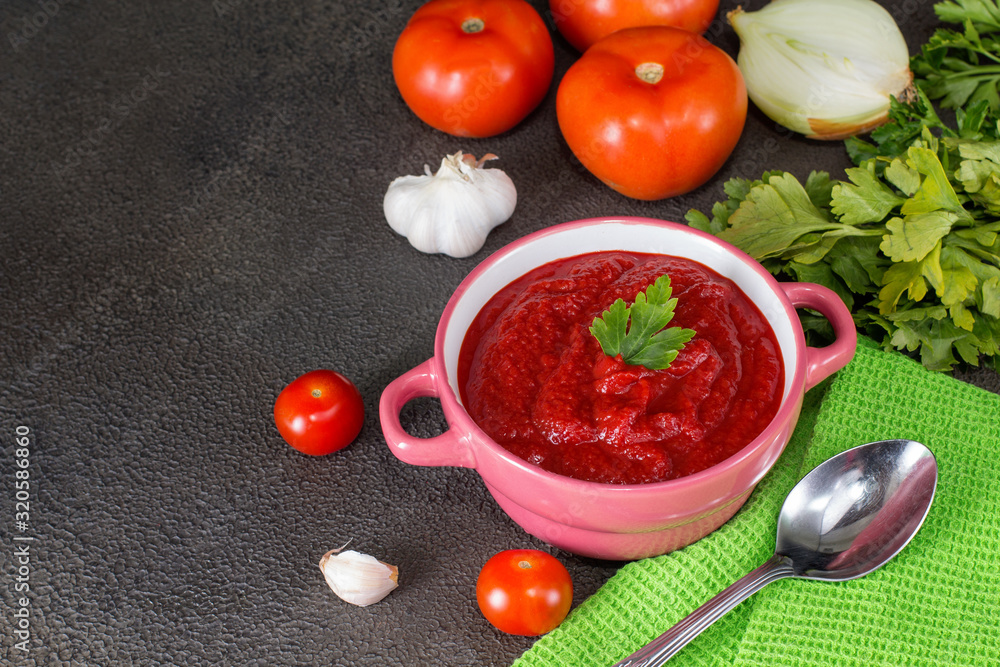 Tomato soup with parsley, onion and garlic on gray background. Comfortable food. Rustic style.. Tomato soup with parsley, onion and garlic on gray background. Comfortable food. Rustic style..