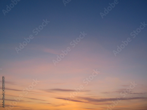Clear sky with small clouds on the horizon at sunset. Beautiful colorful sky at sunset background.
