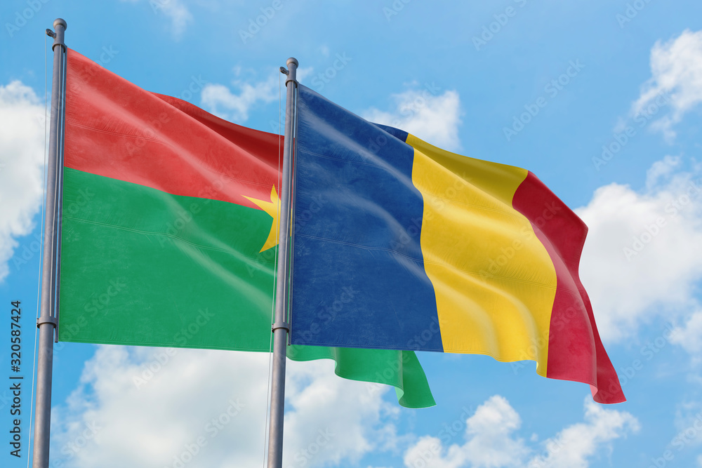 Romania and Burkina Faso flags waving in the wind against white cloudy blue sky together. Diplomacy concept, international relations. Romania and Burkina Faso flags waving in the wind against white cloudy blue sky together. Diplomacy concept, international relations.