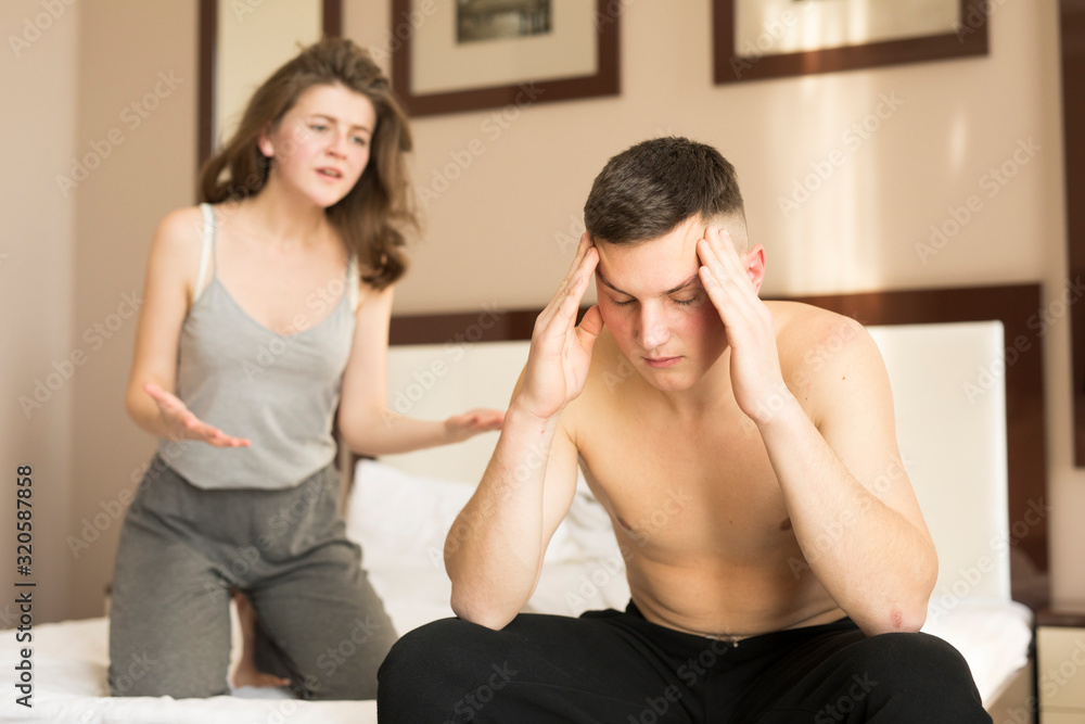 Young couple sitting on bed and quarreling in morning Young couple sitting on bed and quarreling in morning