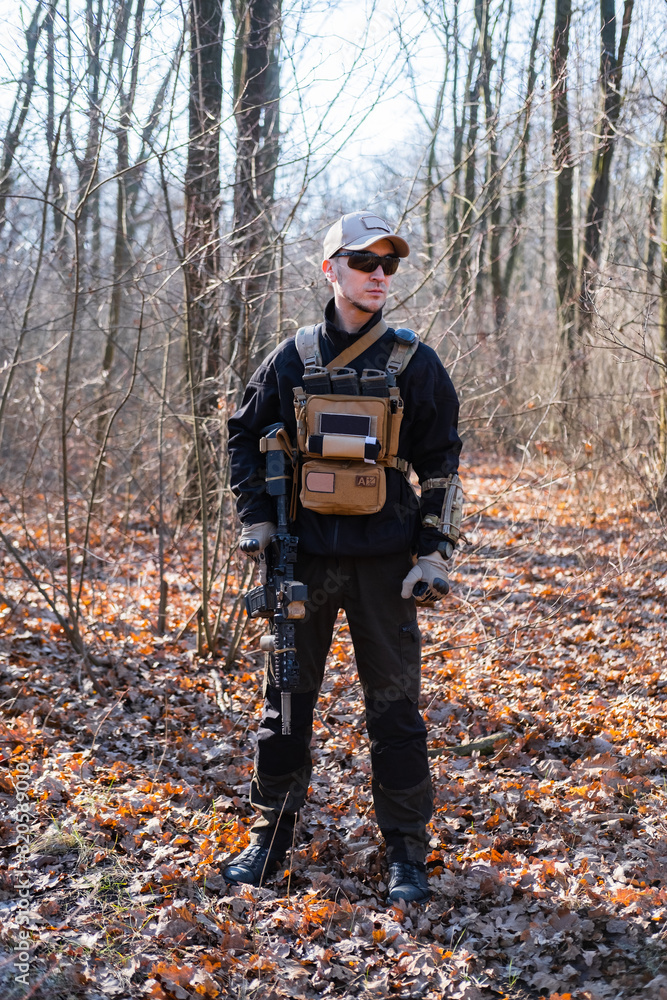 Male from private military company with rifle in the forest Male from private military company with rifle in the forest