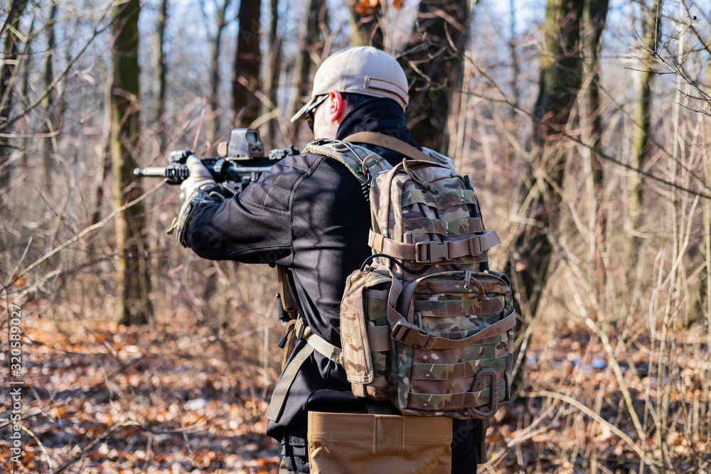 Male from private military company with rifle in the forest Male from private military company with rifle in the forest
