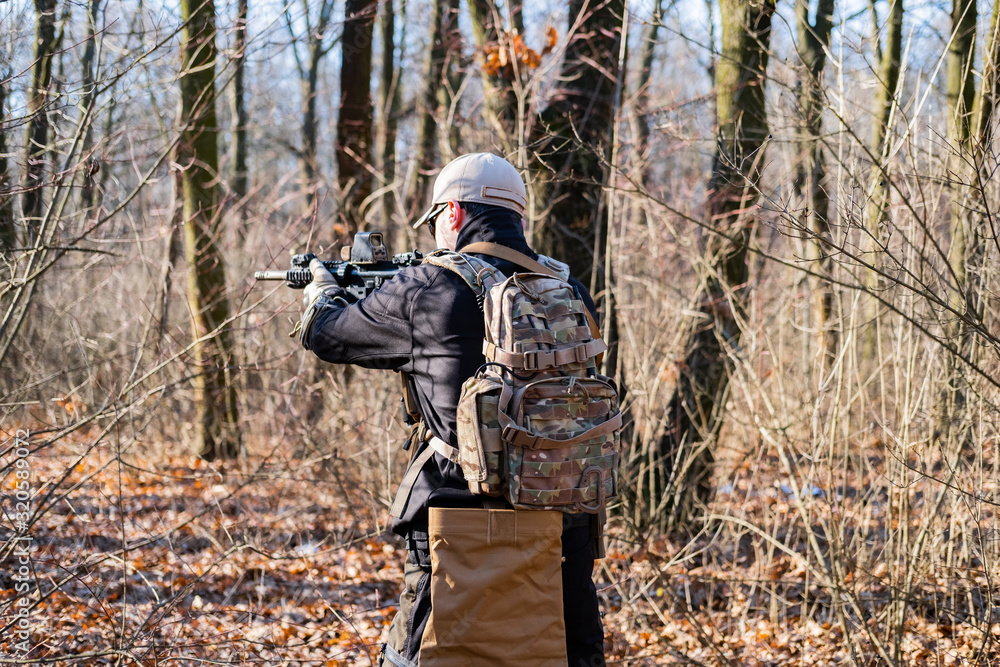 Fototapeta premium Male from private military company with rifle in the forest