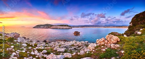 Amazing sunset view with multicolored clouds. Incredibly romantic sunrise on Voidokilia beach  Ionian Sea  Pilos town location  Greece  Europe. View of the ocean through the rocky shore
