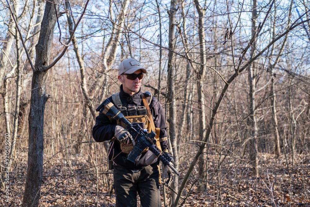Male from private military company with rifle in the forest Male from private military company with rifle in the forest