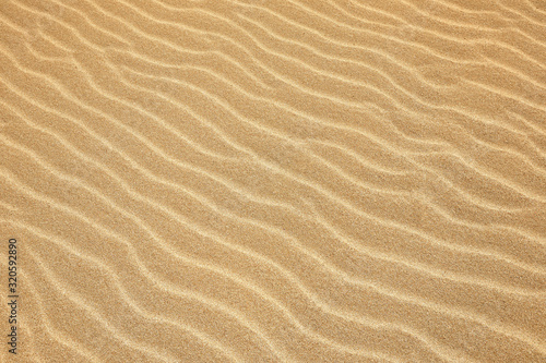 White Sand dunes background texture. Beach and sand texture. Pattern of sand. Beautiful sand dune in sunrise in the desert. Steps on the beach sand.