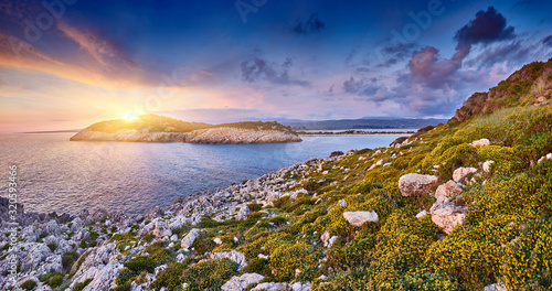Fototapeta Naklejka Na Ścianę i Meble -  Amazing sunset view with multicolored clouds. Incredibly sunrise on Voidokilia beach, Ionian Sea, Pilos town, Greece, Europe. View of the ocean through the rocky shore
