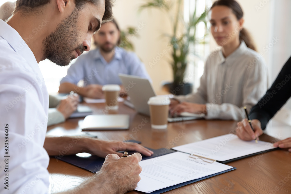 Male employee sign paper document closing deal at meeting