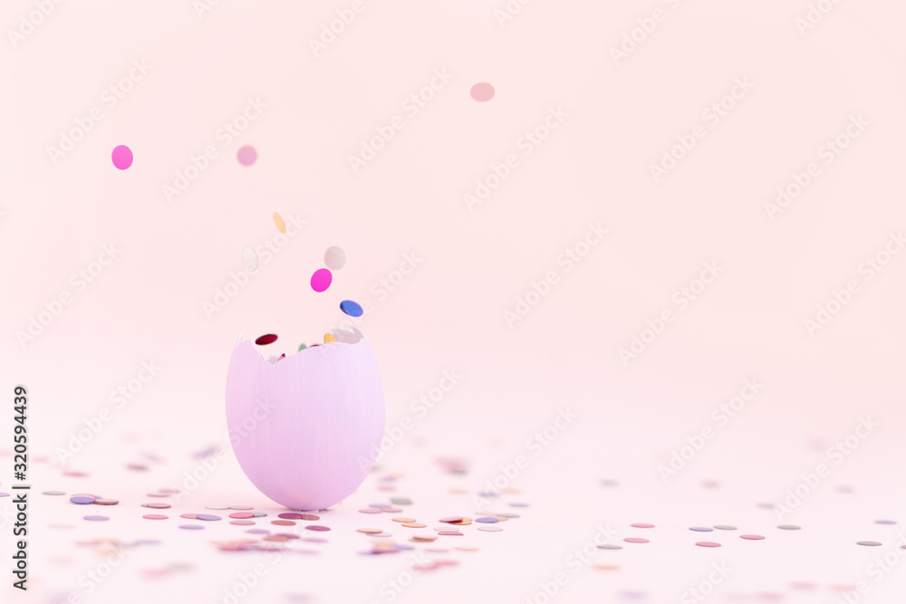 Purple easter eggshell on pastel pink background with flying out colorful confetti. Egg is a symbol of the celebration of a religious holiday among Catholics, Christians and Protestants Purple easter eggshell on pastel pink background with flying out colorful confetti. Egg is a symbol of the celebration of a religious holiday among Catholics, Christians and Protestants