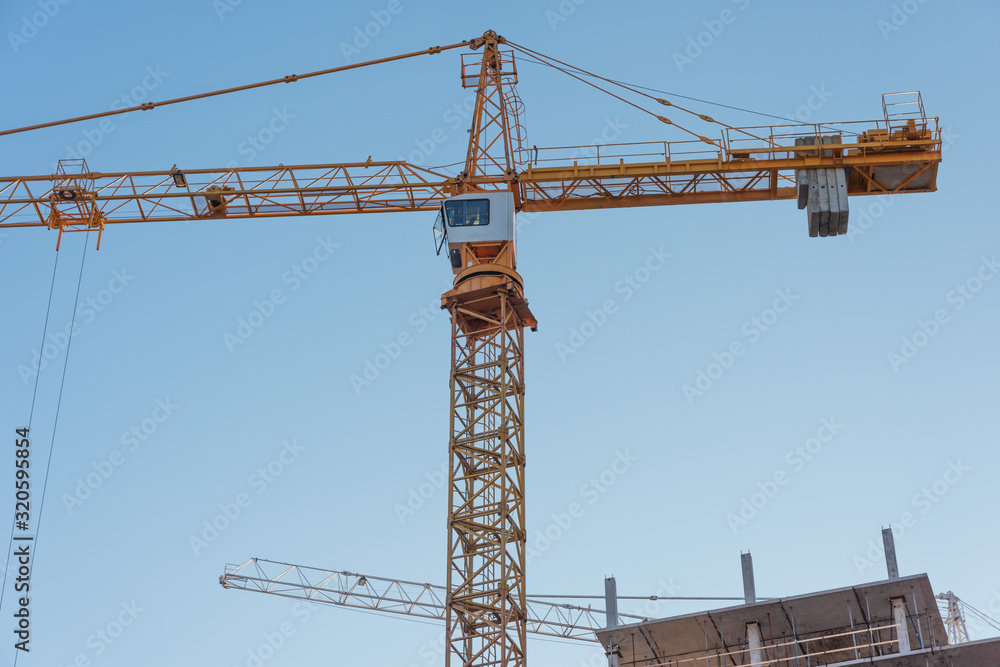 Construction site with high-rise construction cranes.