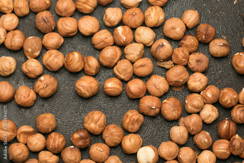 Peeled hazelnuts in a cast-iron pan top view, close-up Peeled hazelnuts in a cast-iron pan top view, close-up