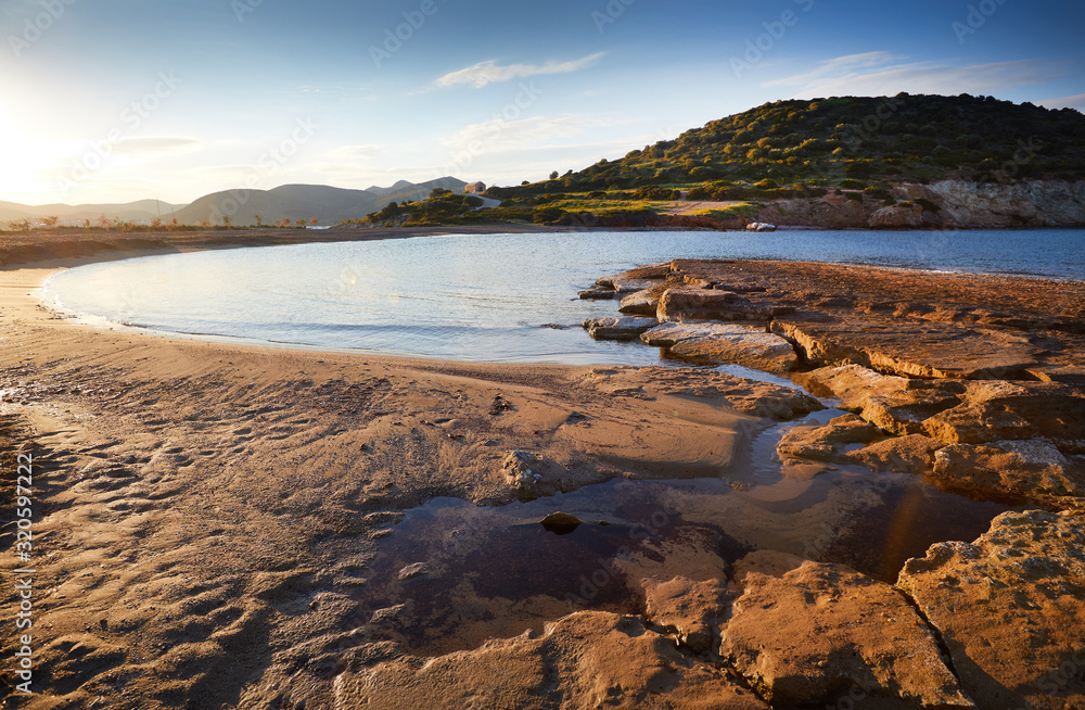 Obraz premium Sunrise on Nuevo Loca Beach. Traveling concept background. Palaia Fokaia, beginning of the beach season. Greece, Europe. Sunny morning seascape. Spring light on the Greek coast, Aegean sea