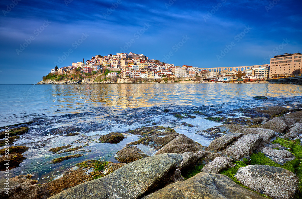Incredibly romantic sunny spring seascape on Aegean Sea. Colorful morning view of Kavala city, eastern Macedonia, Greece, Europe..Beach view in Greece. Beautiful Kavala's view.