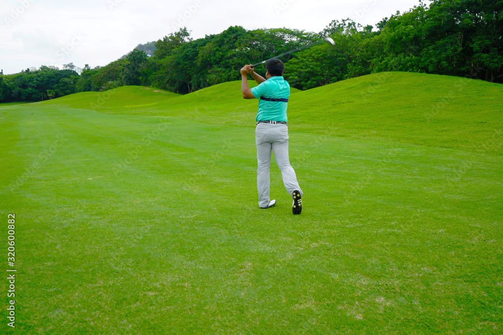 Blurred golfer playing golf in beautiful golf course in the evening golf course with sunshine in thailand Blurred golfer playing golf in beautiful golf course in the evening golf course with sunshine in thailand