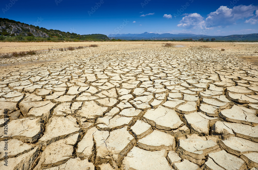 Drought land. Cracked clay ground into the dry season. Drought, no hot water, lack of moisture. Global worming effect. Crack soil on dry season. Abstract natural background with cracked earth texture