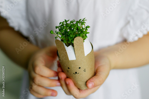 little girl holding an easter bunny with watercress in her hands