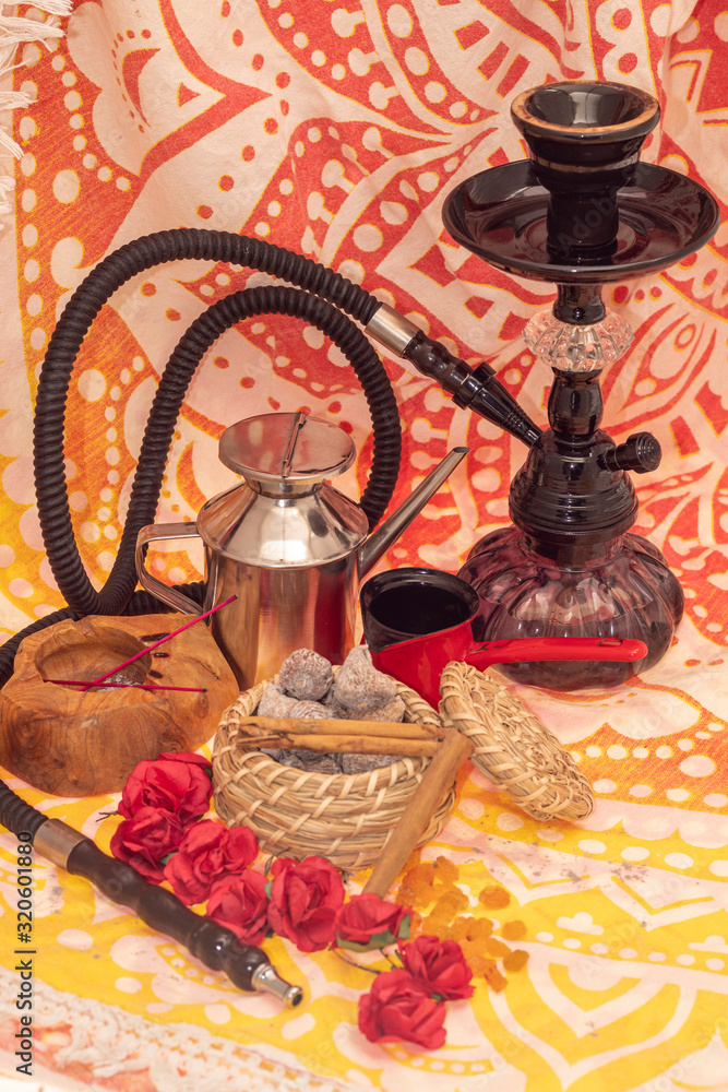 Still life consisting of hookah, flowers, figs, cinnamon, candles and tea-making utensils Still life consisting of hookah, flowers, figs, cinnamon, candles and tea-making utensils