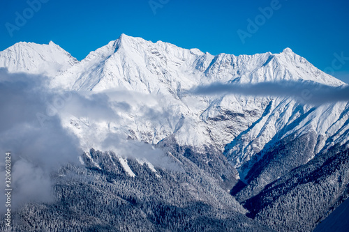 Winter Mountain landscape at the Rosa Khutor ski resort in Sochi, Russia. Trees in hoarfrost against a beautiful morning sky in a frosty morning. Snow cannons sprinkle snow on the slopes © Alexey Oblov