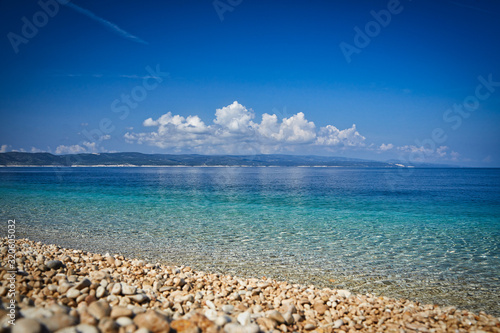 Amazing seascape of Adriatic sea. Colorful summer view of small Brela beach Croatia, Europe. Croatian coast with clear water and pine trees around. Tropical viewpoint for design postcard.
