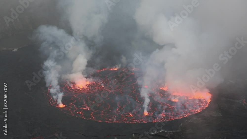 Bubbling lava and smoke in a round crater of Nyiragongo volcano, Congo photo