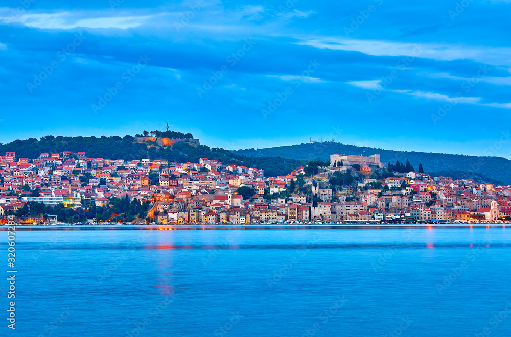 Large panorama of Unesco heritage historic town of Sibenik on Adriatic sea, Dalmatia, Croatia. Shot from the sea, harbor, waterfront and cathedral in front. Dramatic red sky at night. Evening city..