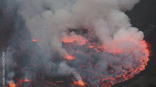 Bubbling lava and smoke in a round crater of Nyiragongo volcano, Congo