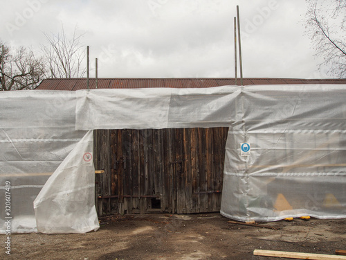 plastic sheets on scaffolding infront of barn © Anders