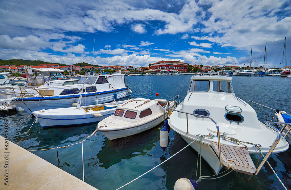Fishing and sailing boats at the harbor. Sunny summer view of Tribunj port. Morning seascape, Adriatic sea, Croatia, Europe. Beautiful world of Mediterranean countries. Traveling concept background..