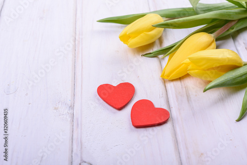 Fototapeta Naklejka Na Ścianę i Meble -  Hearts, ribbon, yellow tulips on wooden background, Valentines Day background