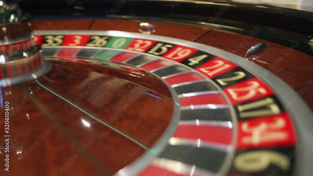 Casino: Roulette in Las Vegas with a white ball. The dealer croupier stops the roulette wheel and throws a game ball. The ball falls on the red field 32. Close-up Casino: Roulette in Las Vegas with a white ball. The dealer croupier stops the roulette wheel and throws a game ball. The ball falls on the red field 32. Close-up