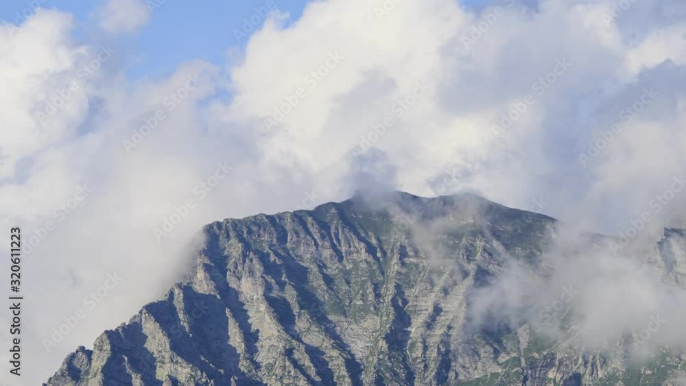 timelapse of clouds moving fast on summit of a mountain in the alps timelapse of clouds moving fast on summit of a mountain in the alps
